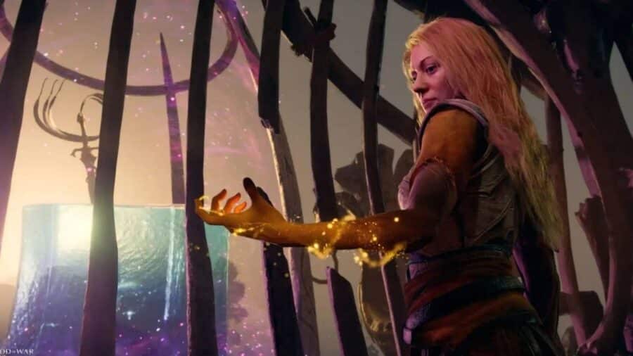 Faye in God of War Laufey osserva una luce dorata nella propria mano, circondata da elementi mistici e radici oscure.
