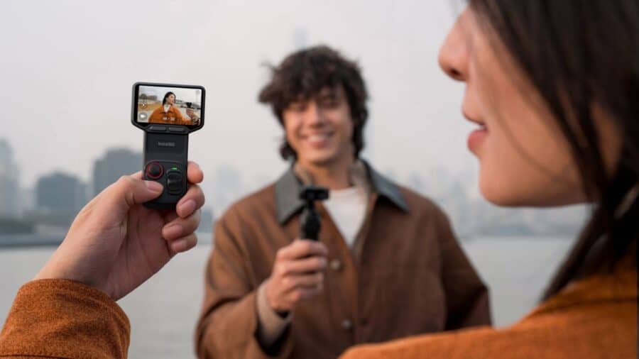 Una persona utilizza Insta360 Luna Ultra per riprendere un uomo all’aperto, controllando l’inquadratura dal display integrato.