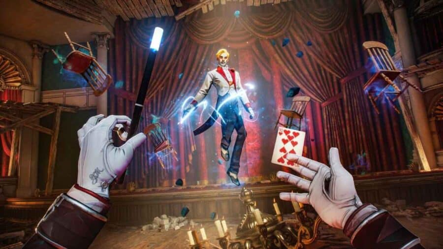 Scena in prima persona di Magicians The Devil’s Deal con il protagonista che usa bacchetta magica e carte da gioco contro un nemico sospeso in un teatro distrutto.