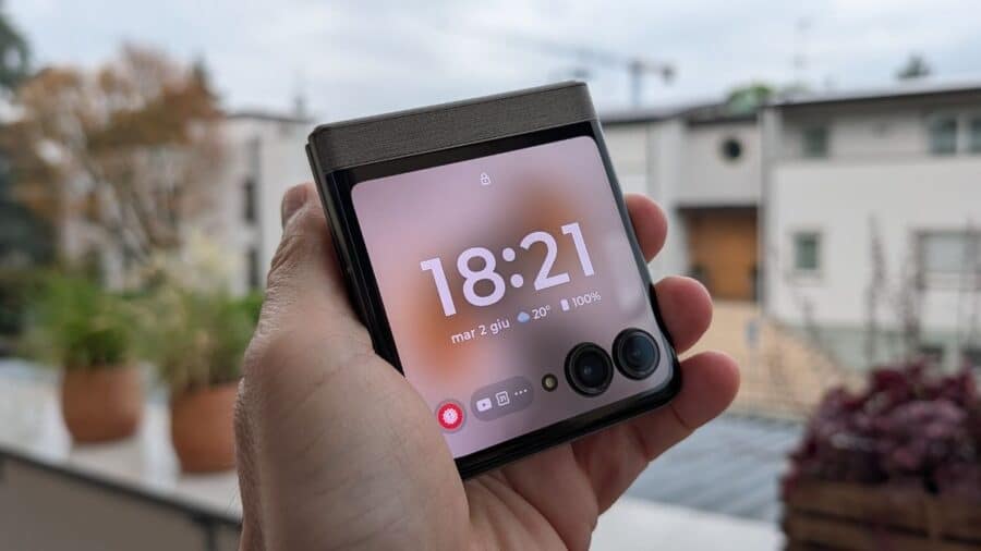 Motorola Razr 70 chiuso in mano con schermo esterno che mostra orario e app