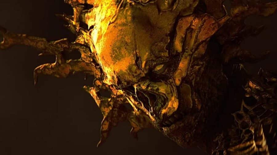 Primo piano di una creatura mostruosa dorata in SAROS, con volto deformato, corna e dettagli organici illuminati da luce gialla.