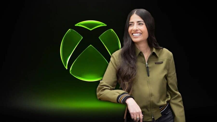 Dirigente Xbox sorridente accanto al logo verde del marchio, su sfondo scuro e illuminazione focalizzata.