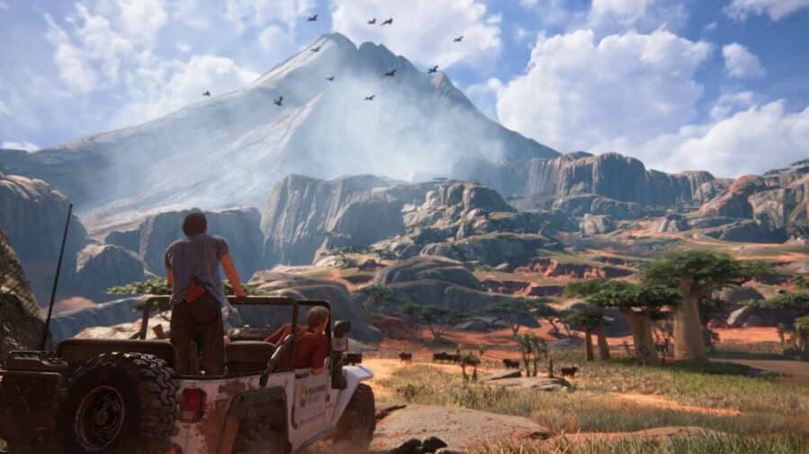 Scena panoramica tratta da un videogioco Naughty Dog, con due personaggi su una jeep davanti a un grande paesaggio montuoso.