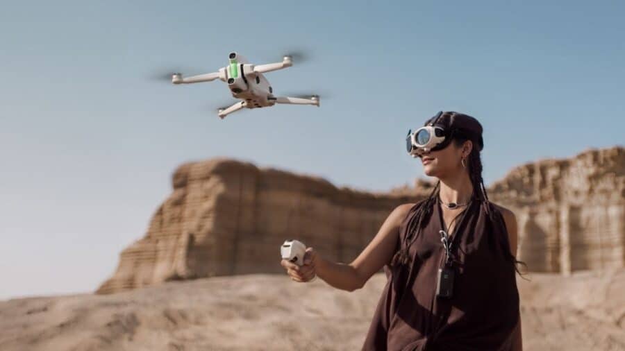 Una donna pilota Antigravity A1 indossando un visore FPV e impugnando il controller in un ambiente desertico.