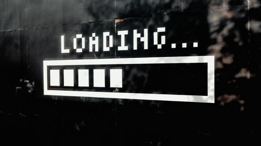 Murale nero e bianco con scritta “Loading…” e barra di caricamento stilizzata su una parete.