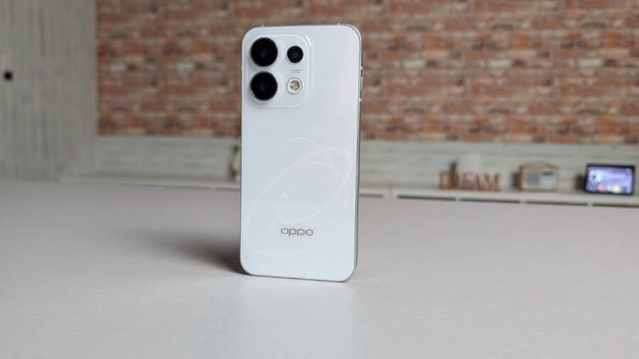 OPPO Reno16 Pro in piedi su sfondo industriale con motivo 3D Pop Planet sul retro