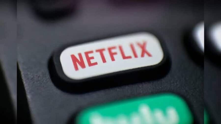 Dettaglio ravvicinato del pulsante bianco con il logo rosso di Netflix presente sul telecomando di una smart TV.