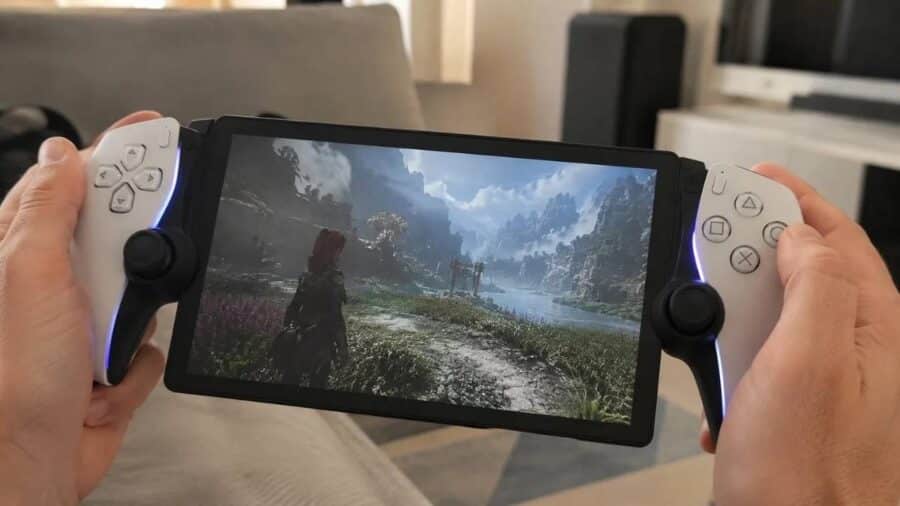 Un utente tiene in mano una console portatile con impugnature bianche simili a quelle del controller DualSense, mentre sullo schermo viene riprodotto un videogioco in un'ambientazione naturale.