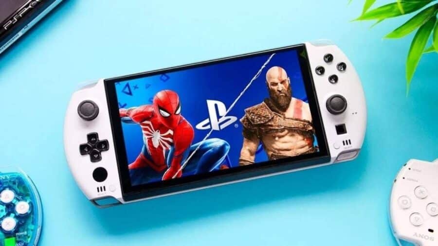Una console portatile dal design bianco e nero mostra sullo schermo un'immagine promozionale con Spider-Man e Kratos, circondata da vari accessori e vecchie console da collezione poggiate su una superficie azzurra.