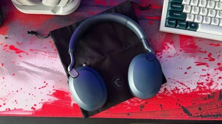 Cuffie MSI Maestro 500 Wireless di colore blu scuro, ripiegate su se stesse e appoggiate sopra la loro custodia nera in tessuto su una colorata scrivania da gaming.