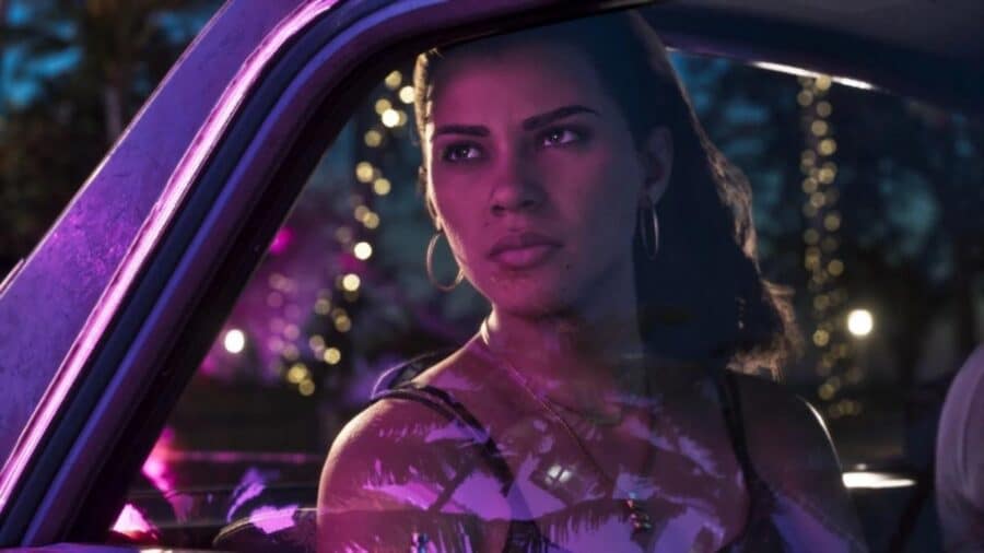 Primo piano di Lucia all'interno dell'abitacolo di un'auto di notte, con orecchini a cerchio e lo sguardo serio rivolto fuori dal finestrino tra riflessi e luci al neon viola.