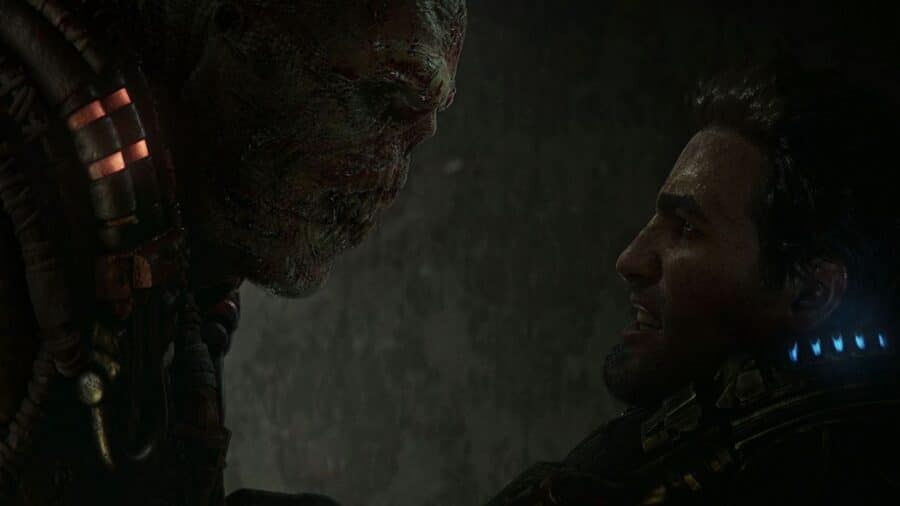 Primo piano di un giovane Marcus Fenix e di Dominic Santiago in pesanti armature da combattimento COG, illuminati da una torcia tattica nel buio.