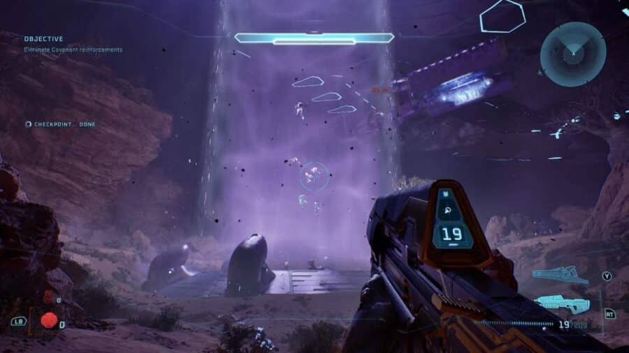 Visuale in prima persona in Halo Campaign Evolved: il giocatore impugna il fucile d'assalto e osserva un raggio di luce viola che teletrasporta truppe nemiche in una gola rocciosa buia.
