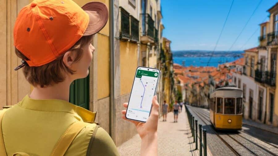Ragazza con cappellino arancione usa Google Maps su Redmi Note 17 per orientarsi tra le vie di Lisbona
