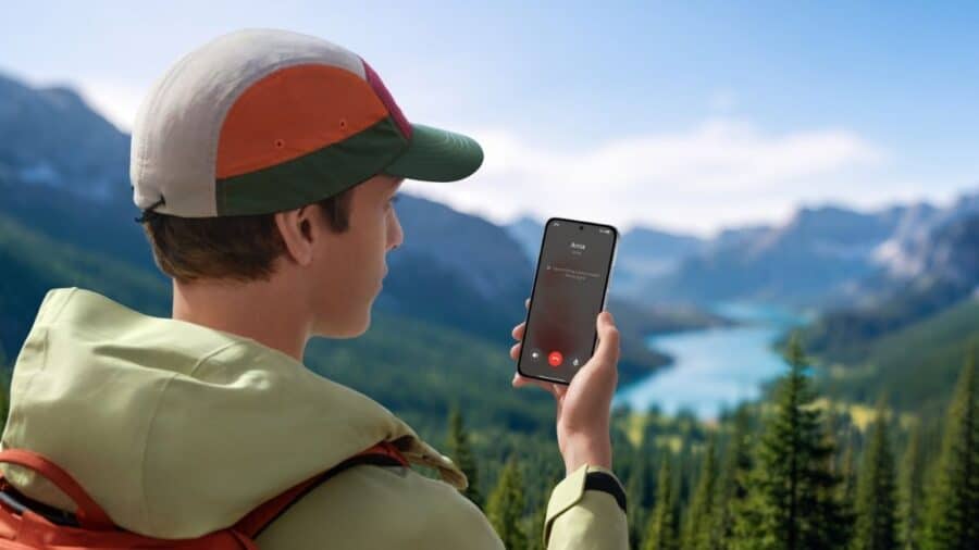 Ragazzo con Redmi Note 17 in mano durante una chiamata in un paesaggio di montagna con lago