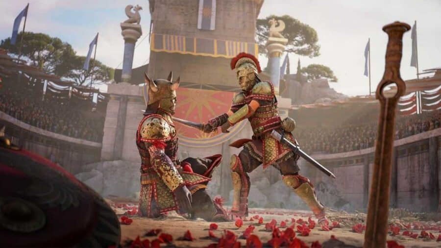 Due guerrieri con armature dorate ed elmi decorati dell'antica Grecia si affrontano nell'arena sabbiosa di un anfiteatro cosparsa di petali rossi, con uno dei combattenti inginocchiato davanti alla lama dell'altro.