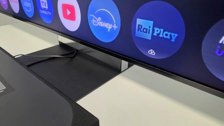 Dettaglio della cornice inferiore del BRAVIA 9 II con icone delle app Disney+ e RaiPlay e cavo della soundbar Trio
