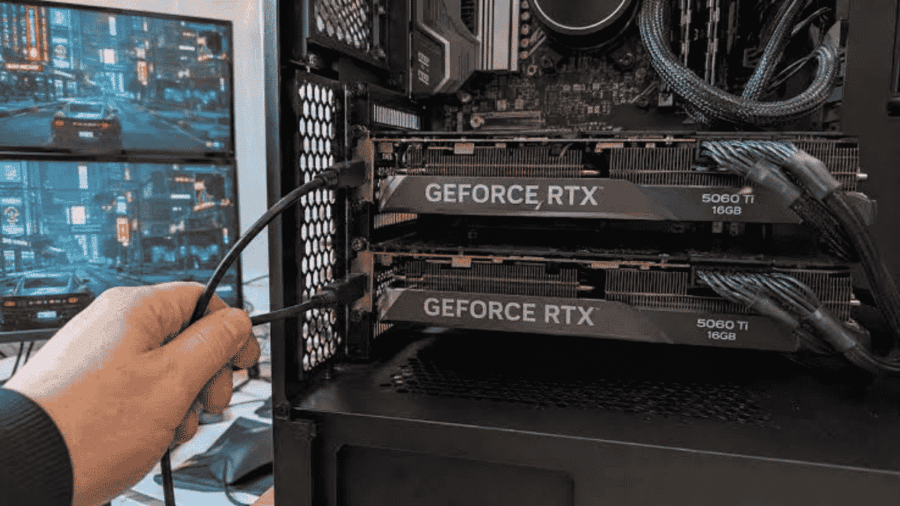 Interno di un computer da gioco con due schede video GeForce RTX 5060 Ti collegate in parallelo e una mano che inserisce un cavo, in una configurazione multi-GPU sperimentale.
