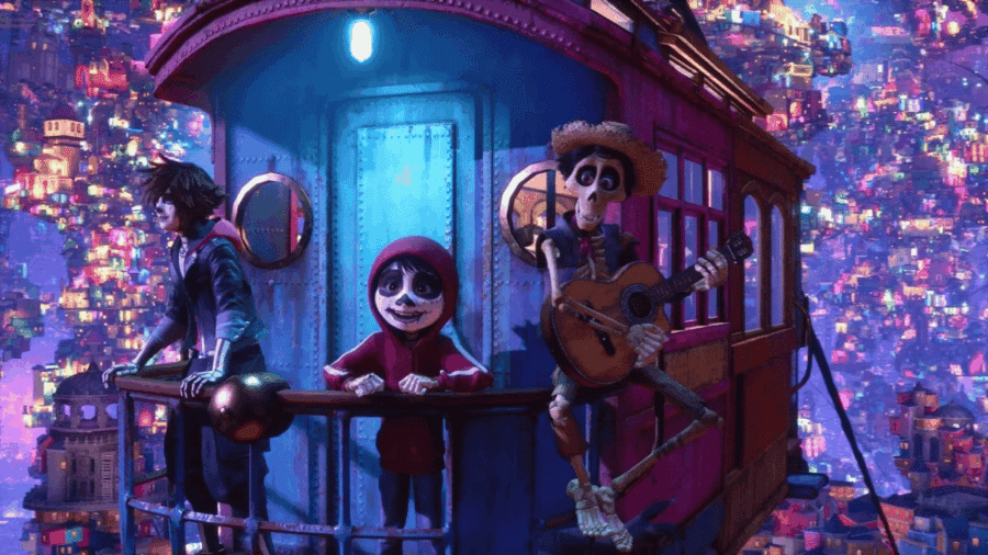 Sora con trucco da scheletro, Miguel ed Héctor affacciati dal ballatoio di una funivia panoramica sospesa sopra la scintillante Terra dei Morti del film Pixar Coco in Kingdom Hearts 4