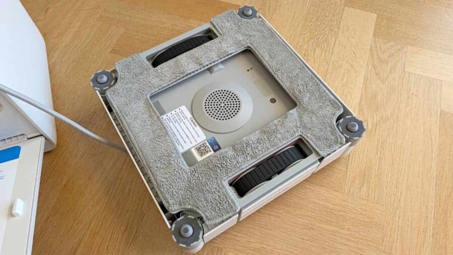 Ecovacs WINBOT W2S Pro Omni visto dal basso, con panni di pulizia, ventose e ruote in evidenza