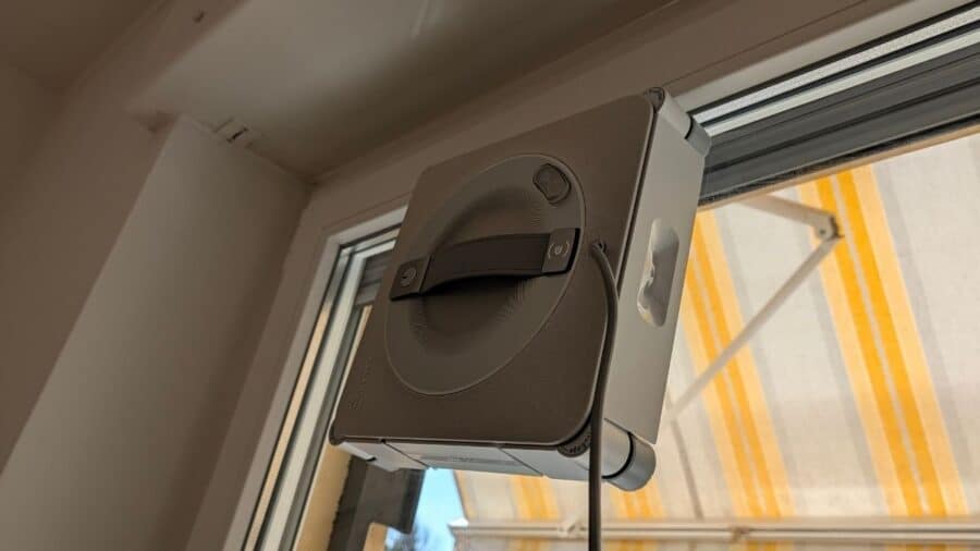 Ecovacs WINBOT W2S Pro Omni applicato all'angolo di una finestra interna vicino alla tapparella
