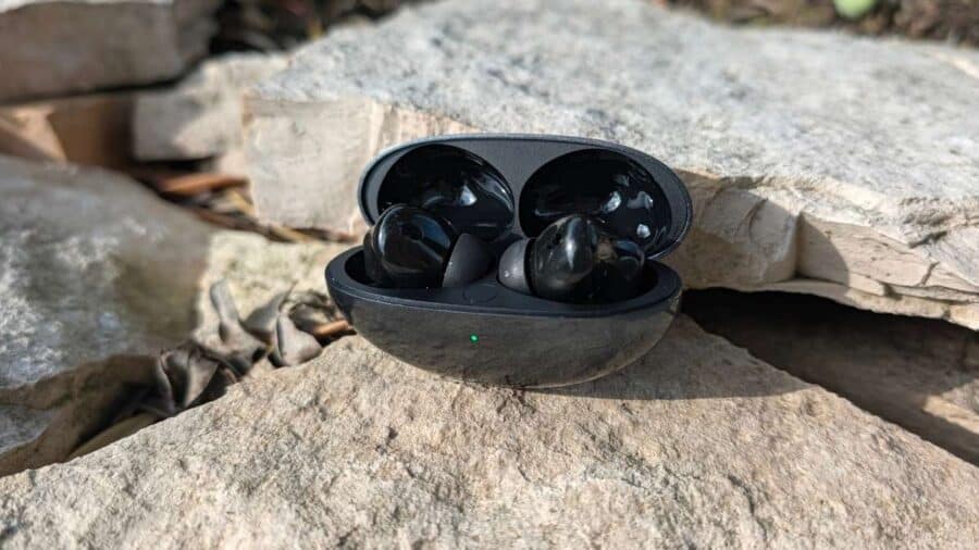 Huawei FreeBuds Neo con custodia aperta appoggiata su rocce all'aperto