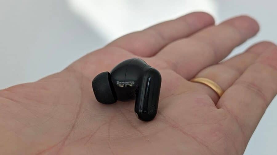 Huawei FreeBuds Neo appoggiato su una mano, vista laterale con gommino