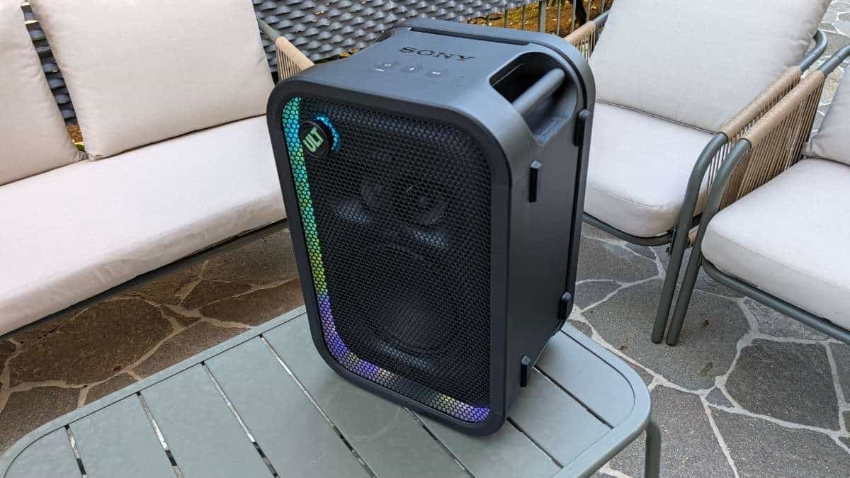 Sony ULT Tower 5 inclinato su un tavolo da esterno con illuminazione LED arcobaleno e manopola ULT accesa
