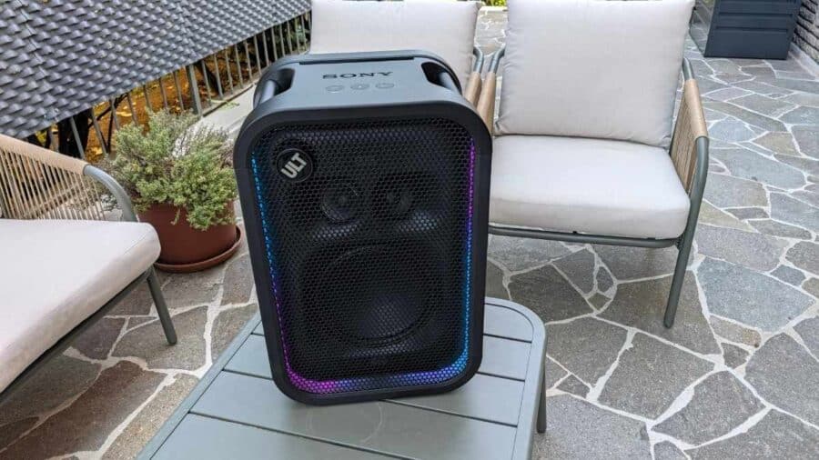 Sony ULT Tower 5 posizionato in verticale su un tavolo da esterno con illuminazione LED multicolore attiva