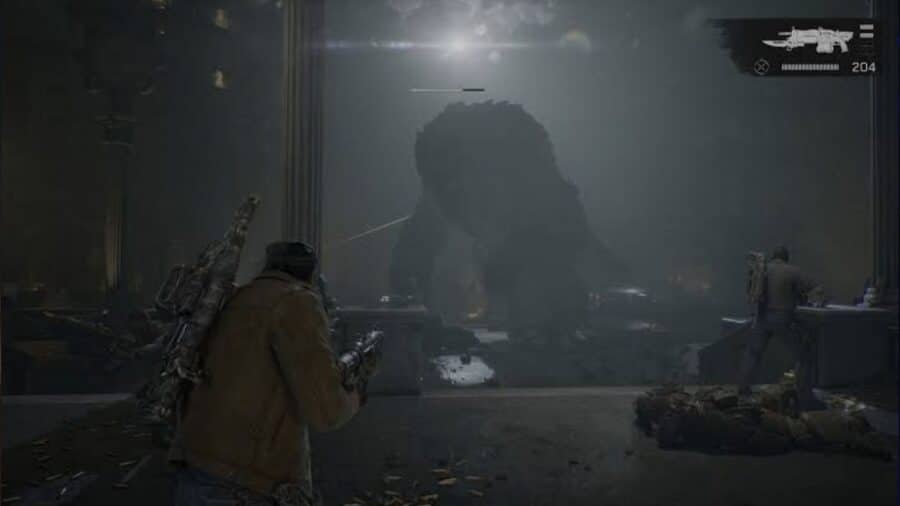 Schermata di gioco in terza persona con contatore delle munizioni e interfaccia dell'arma a schermo, in cui due Gears scorgono l'imponente sagoma di una creatura colossale immersa nella nebbia.