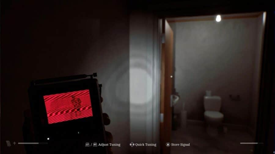 Visuale in prima persona di Simon che regge un piccolo televisore portatile con schermo a righe rosse e la sagoma di un nemico, mentre la torcia illumina l'ingresso di una stanza buia.